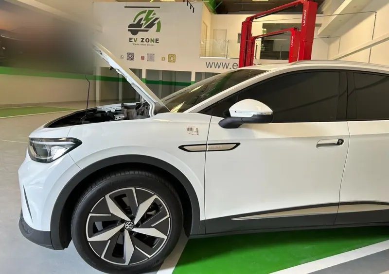 A white Volkswagen ID.4 with its bonnet open in a service bay at the EV Zone workshop in Sharjah