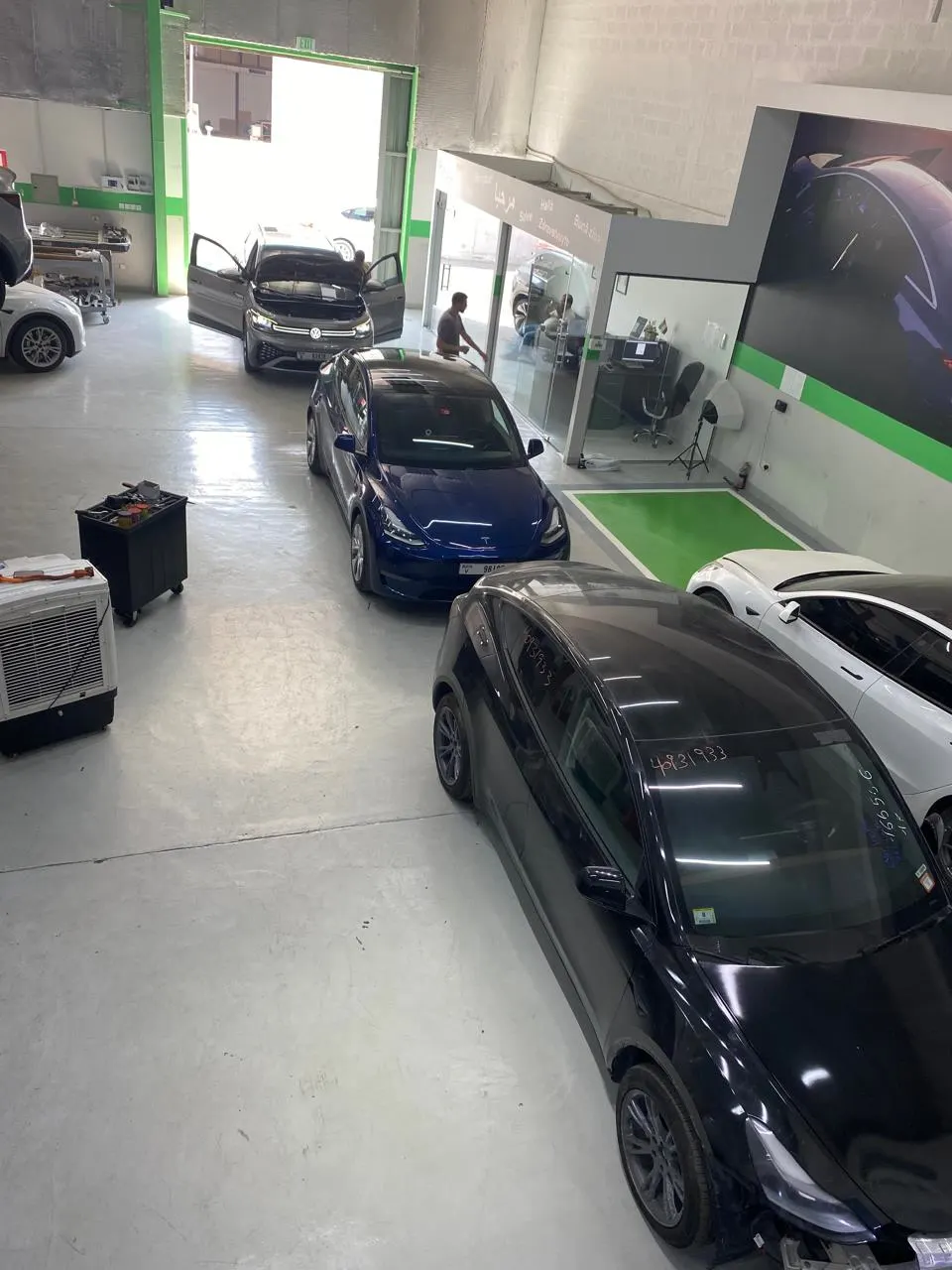 A Tesla Model Y among other electric cars on the EV Zone workshop floor
